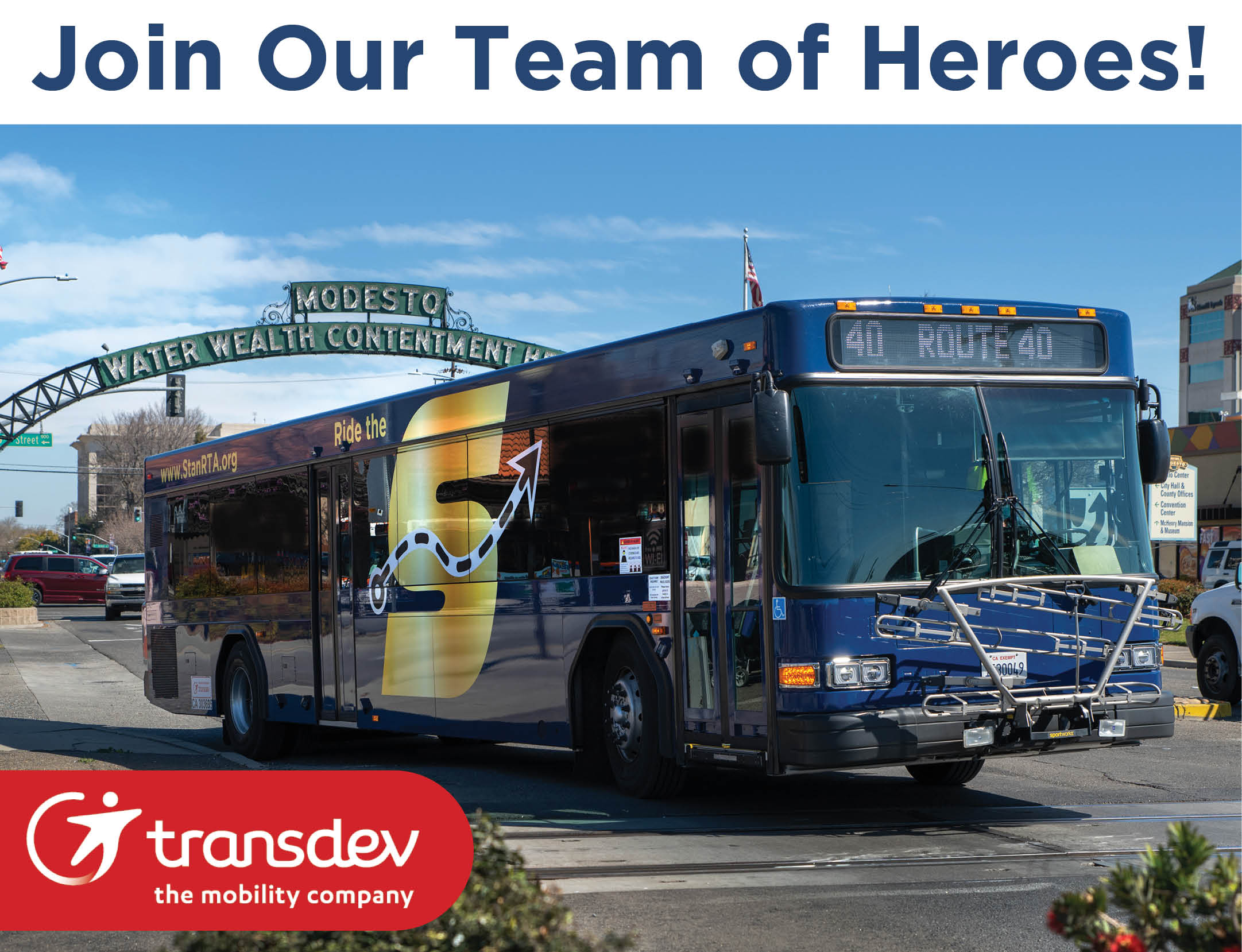 Join our team of heroes! Image of The S bus driving under Modesto arch, Transdev logo