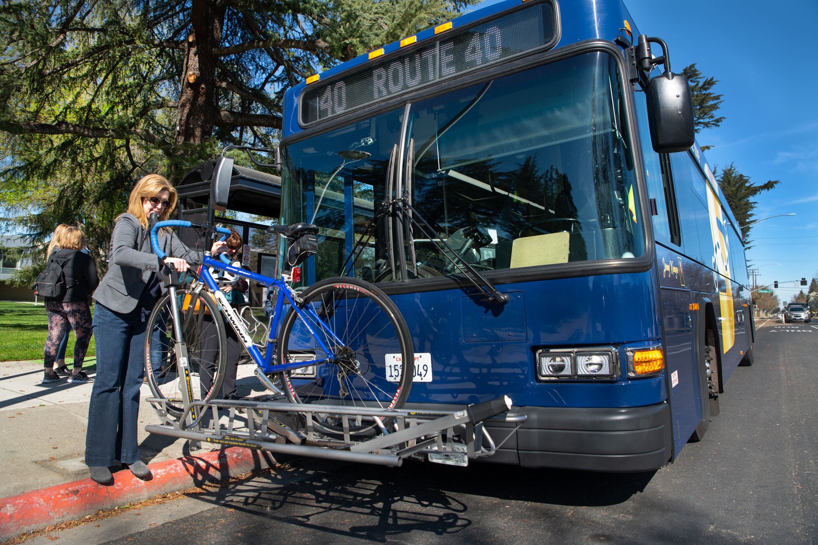 Woman taking her bike off the front of the bus