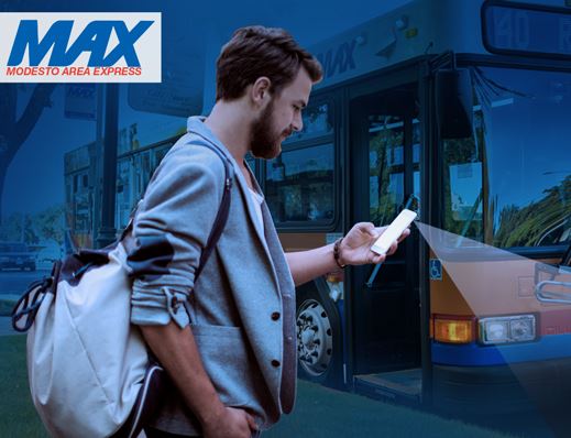 Man with phone in hand next to Modesto Area Express bus